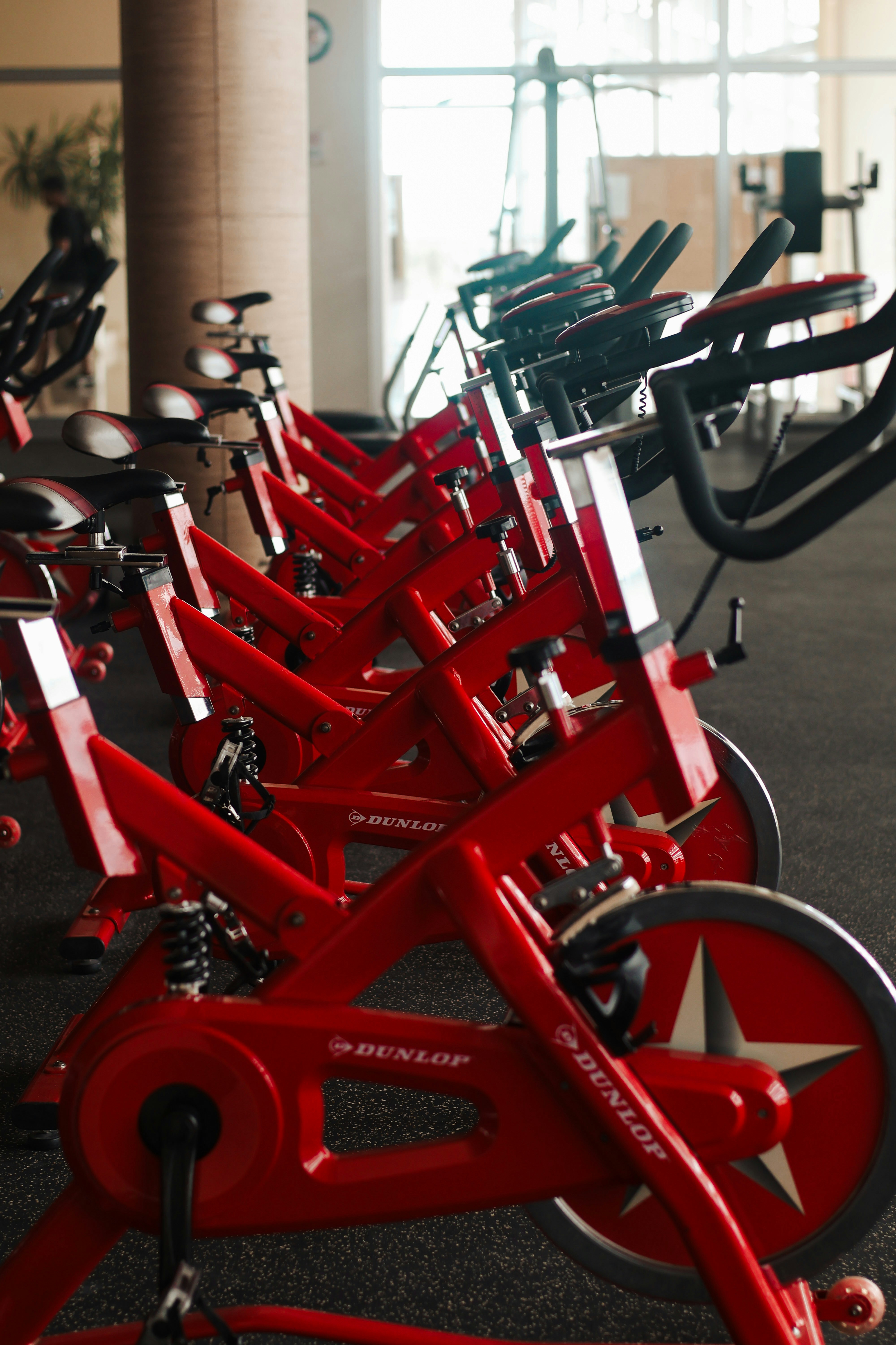 Row of red spin bikes inside a modern gym studio